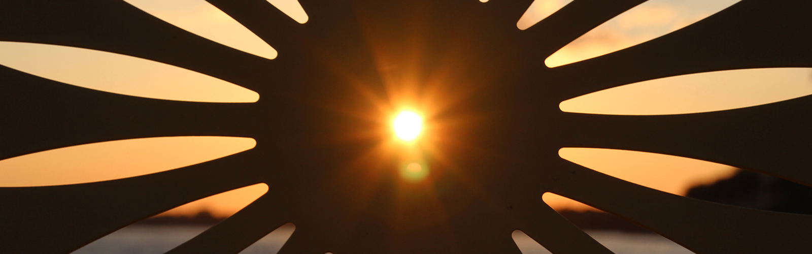 the sunrise shines through the center hole of a memorial union chair.