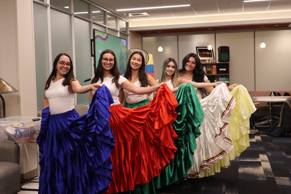Students from Colombian Badgers pose for a photo wearing traditional skirts