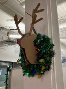 *Wreath with colorful thin plastic lights and reindeer with red nose in middle*