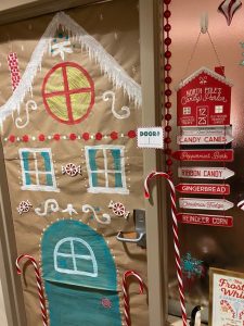 *Painted ginger bread house decorates door, tall plastic candy canes and signage by door and window*