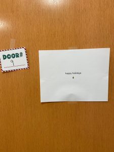 *Paper taped to door that reads happy holidays with small tree emoji*