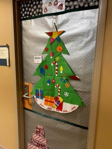 Door wrapped in silver paper, green paper tree on top with multicolored star, candy canes, presents, snowflakes, etc.*