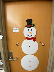 *Door decorated with paper snowman with red scarf and tophat*
