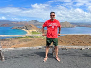 Diego Roman in front of landscape with lakes and mountains in the distance