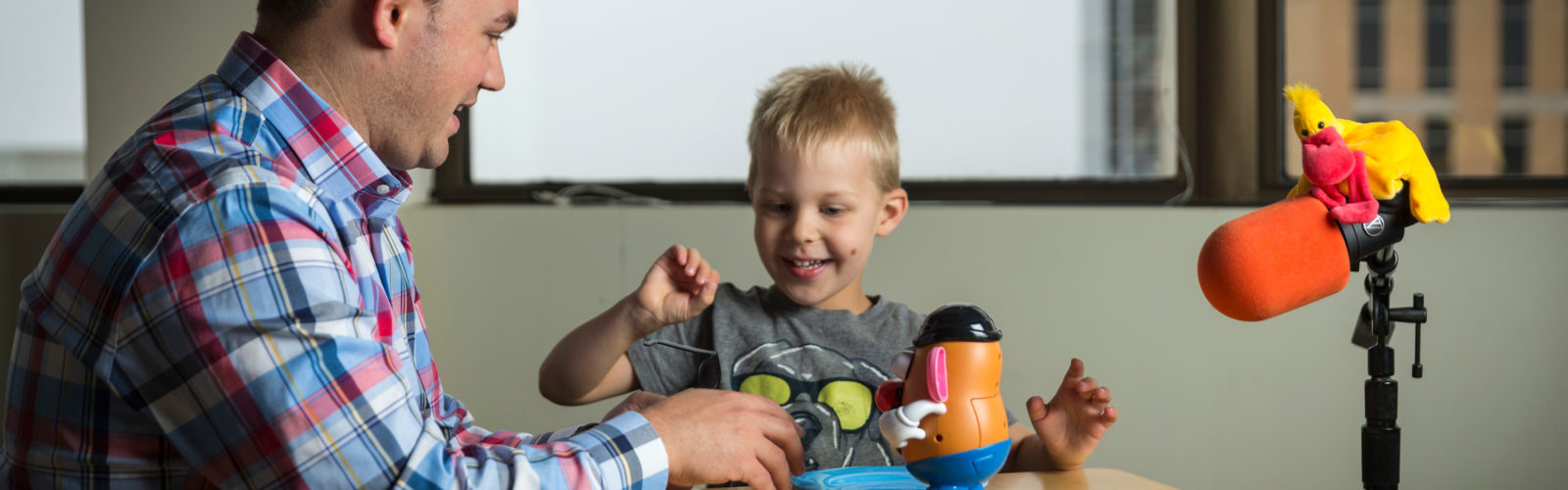 Image of child and lab member with play materials