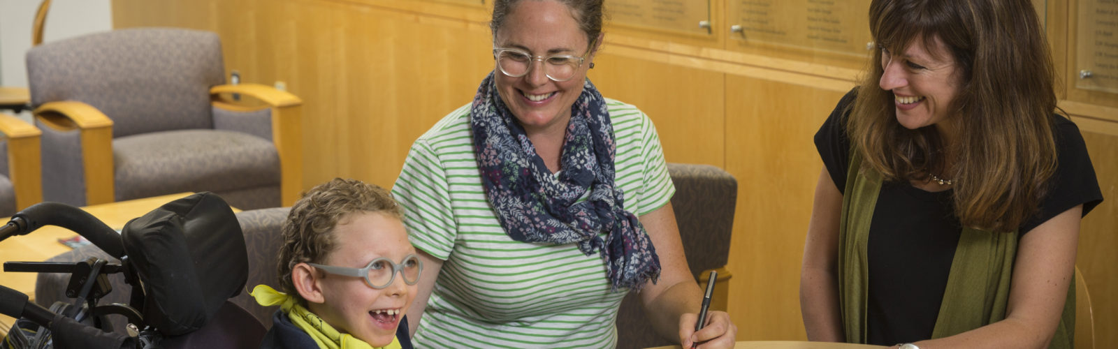 Image of parent, child, and lab member at table