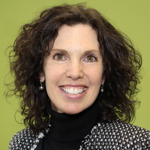 Headshot of woman with dark curly hair with a lime green background.