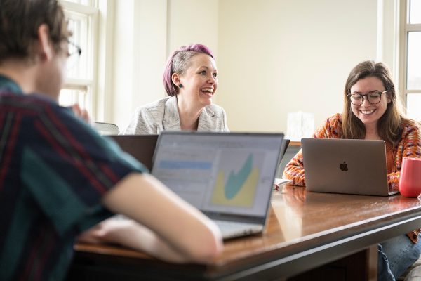 Margaret “Maggie” Kerr (at center with purple hair), assistant professor in the Department of Human Development and Family Studies in the School of Human Ecology, interacts with graduate students in her lab as the group uses their laptop computers to practice use of new statistical software during a team meeting in Nancy Nicholas Hall at the University of Wisconsin–Madison on March 3, 2023. Pictured with Kerr are graduate students.