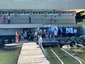 Photo taken from end of Hasler Lab dock looking back at Hasler Lab building during Open House. Many people standing on dock closest to building with posters presentations