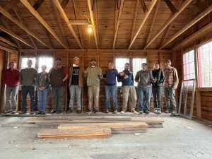Crew of people standing in a line inside newly cleaned out building