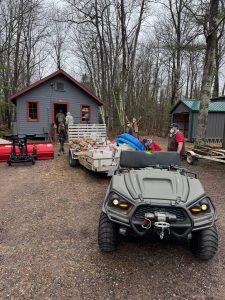 ATV with trailer in front of small outbuilding items from cleaning out
