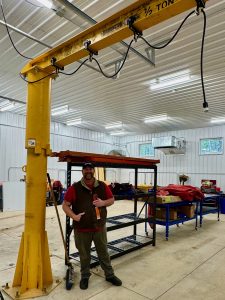 Large yellow lift in new garage with Jonathan Lytle standing to te side