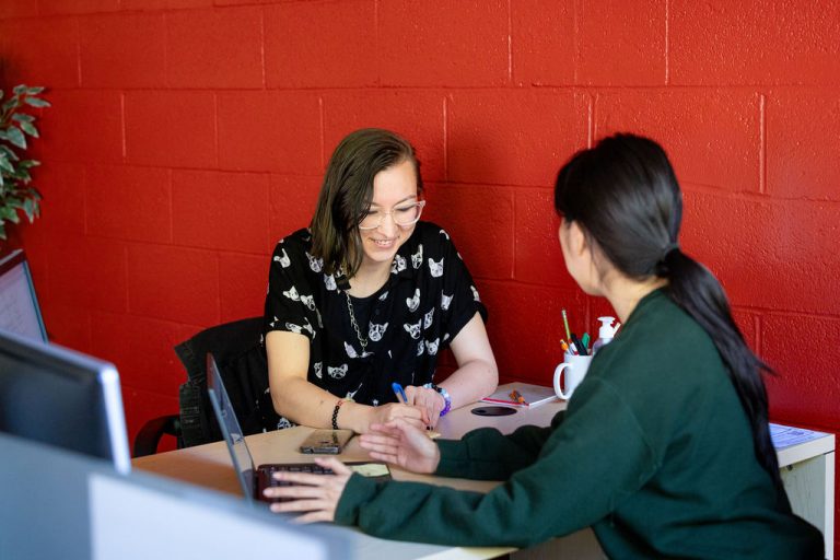 CCAS Peer advisor smiling at an office desk