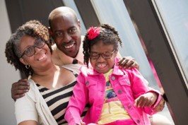 An outdoor image of a mother, father, and daughter