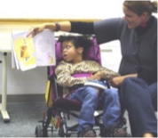 Young boy in a wheelchair with his mom sitting next to him